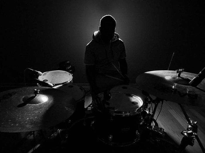 Drummer with musical instruments performing at stage
