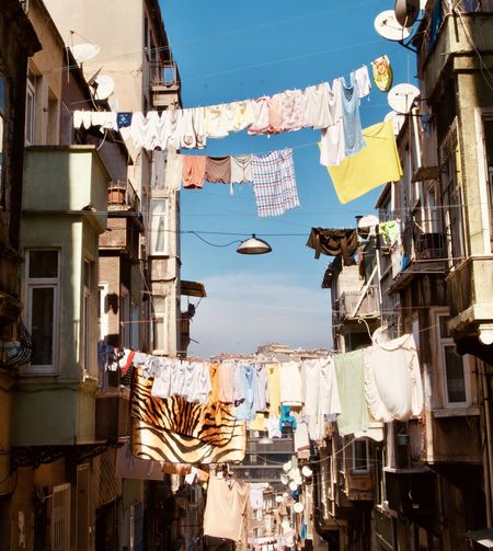 Low angle view of clothes hanging on buildings in city