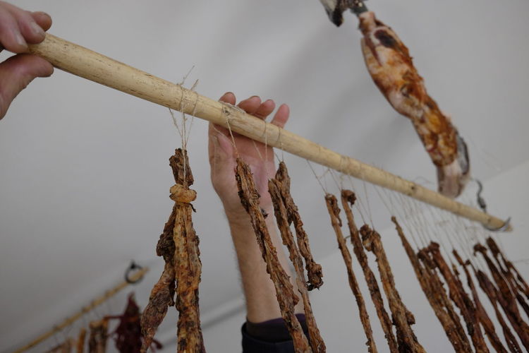 Cropped hand hanging meat on stick