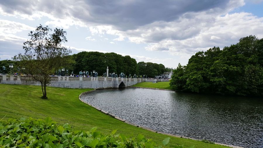 Scenic view of park against cloudy sky