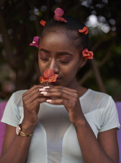 Portrait of young woman smelling a flower