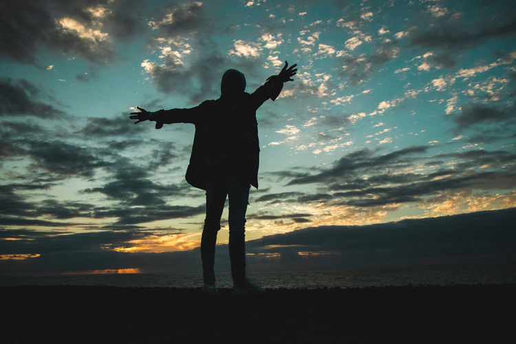 Silhouette man standing against sky during sunset