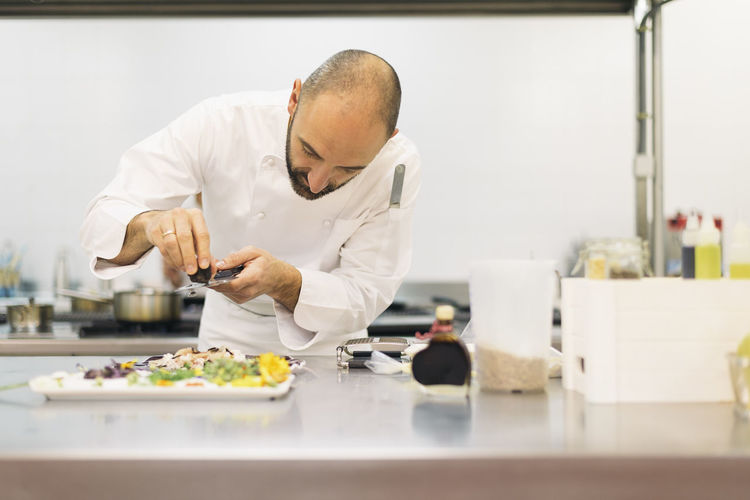 Chef garnishing food in commercial kitchen
