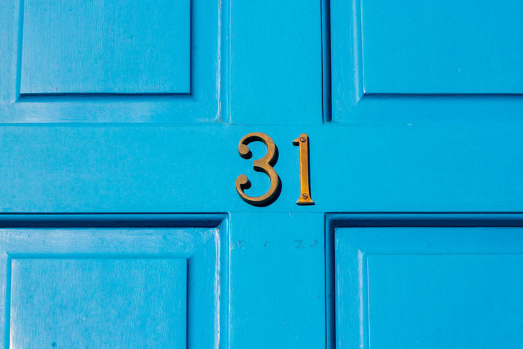 House number 31 on a blue wooden front door in london 