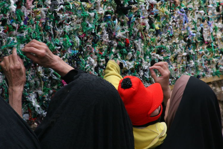 Women tying fabric on wall