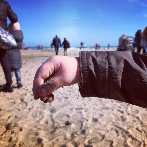 Cropped hand of child at beach