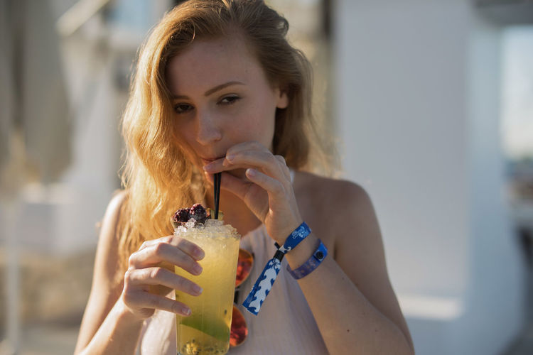 Portrait of young woman drinking cold drink