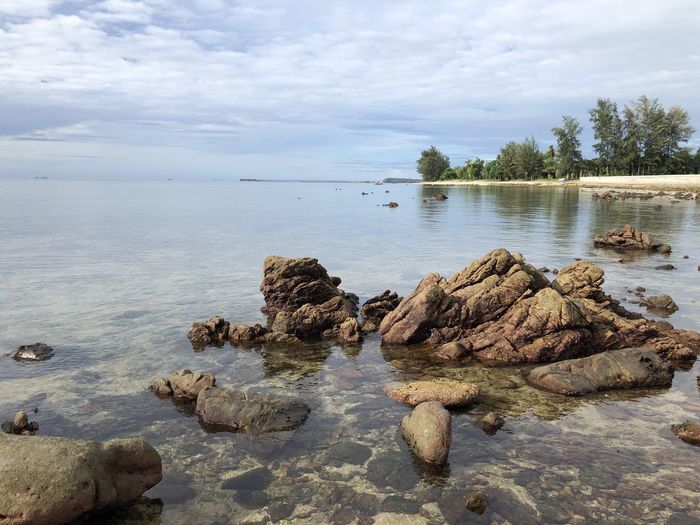 Scenic view of rocks in sea against sky