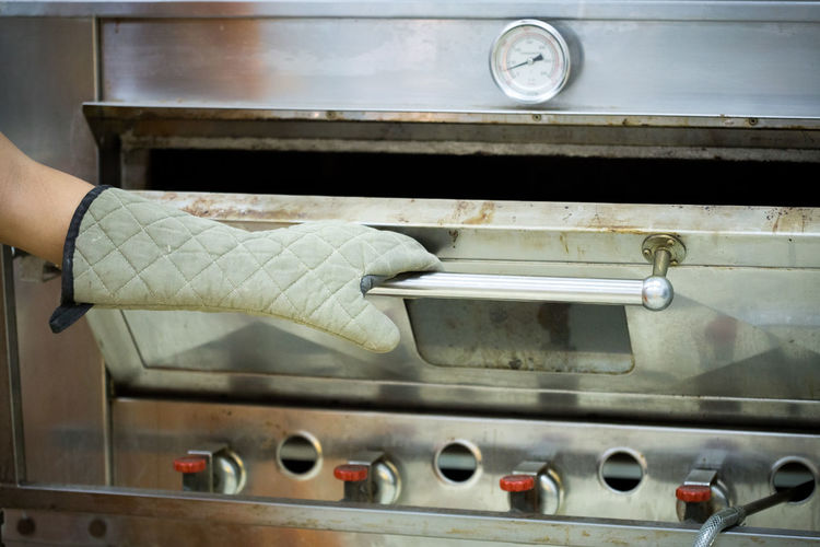 Cropped hand holding oven