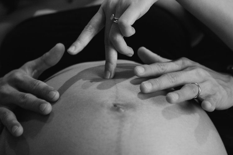 Cropped hand touching pregnant abdomen