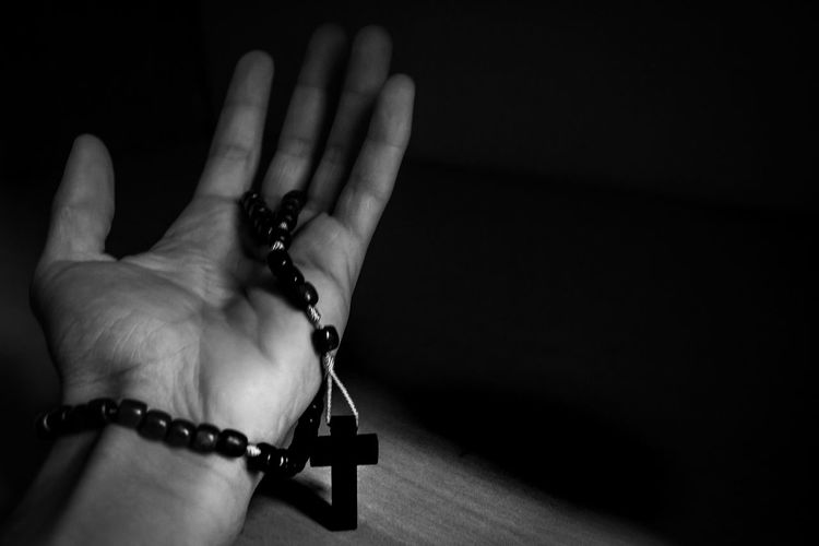 Close-up of hand holding hands against black background