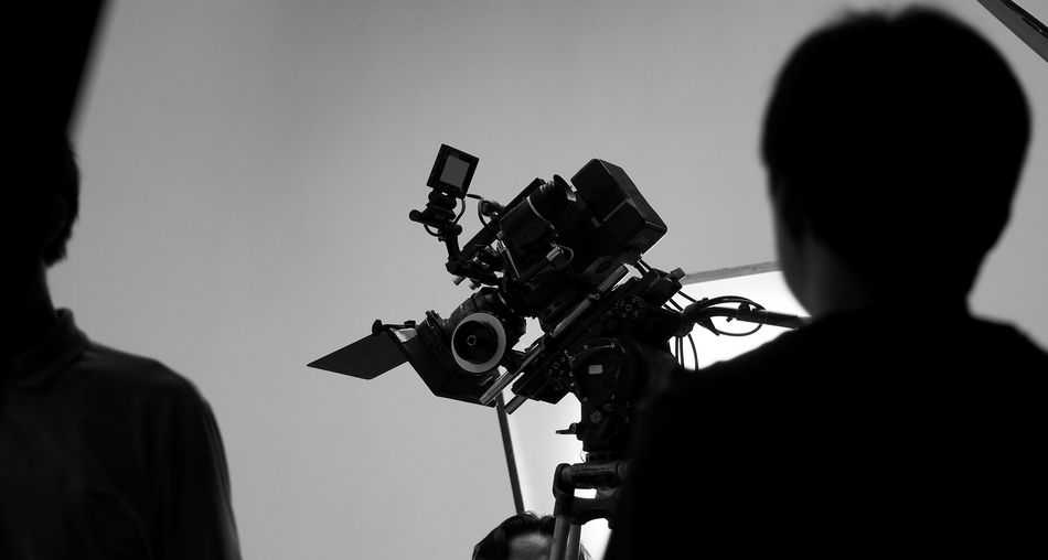Rear view of operator using camera in studio