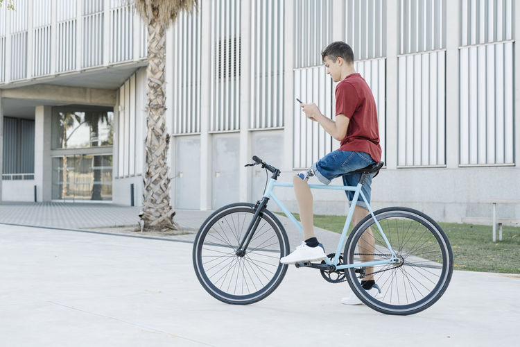 Side view of young man riding bicycle