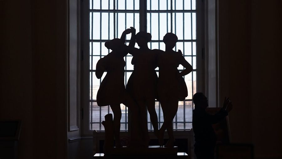Silhouette men standing against window