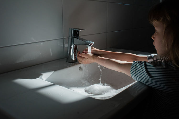 Young child washing their hands at home