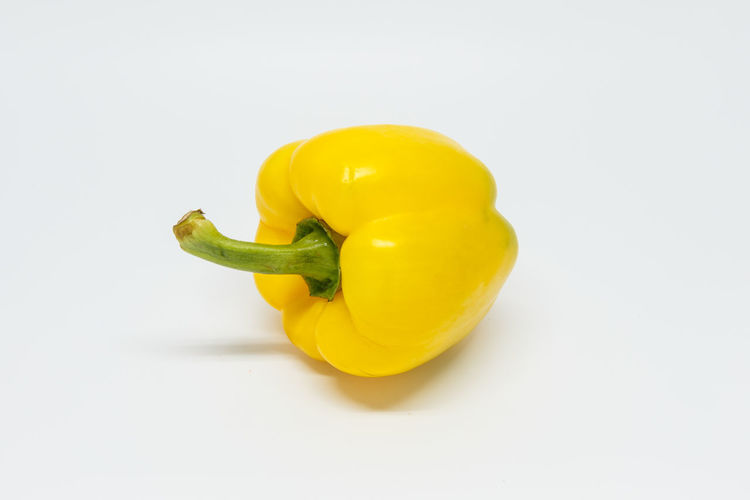 High angle view of yellow bell pepper against white background