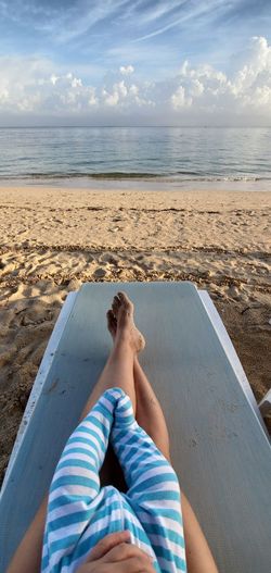Top view of mother and baby legs on a beach chair by the water