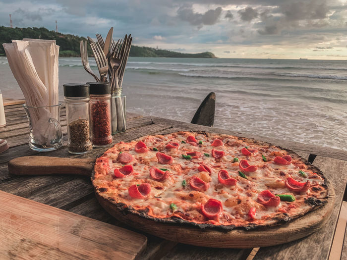 High angle view of pizza on table by sea against sky