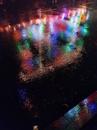 Abstract image of illuminated lights on wet surface
