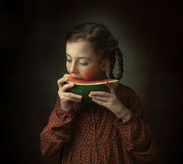 Portrait image of a girl who eats a piece of watermelon, healthy food and the concept of children