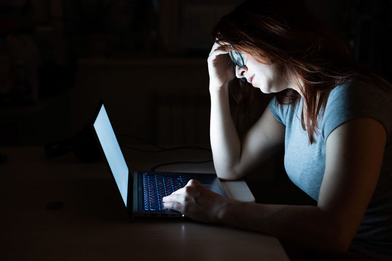 Tired woman using laptop at home