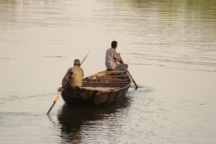 Men sitting in boat on lake