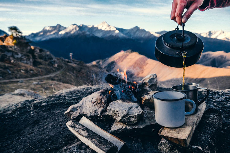 Midsection of person having food against mountains