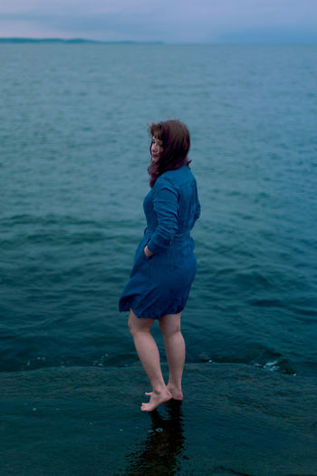 Young girl on a background of the sea in a blue dress, portrait