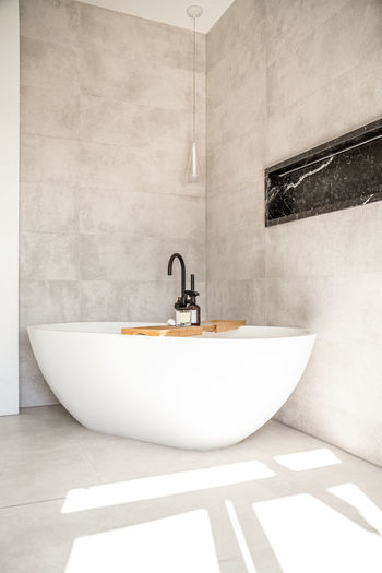 Modern interior of bathroom with white bathtub and ceramic in minimal style