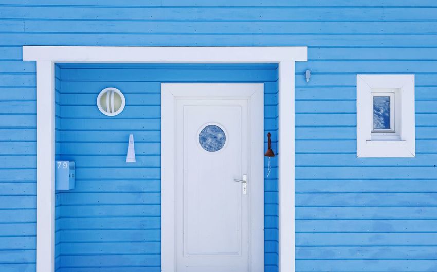 Closed door and windows of building in blue and withe color. 