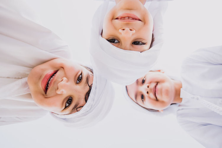 Low angle portrait of cute brothers wearing traditional clothing against clear sky