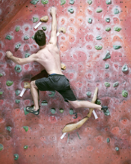 Full length of shirtless man climbing