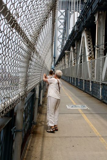 Woman standing on bridge in city