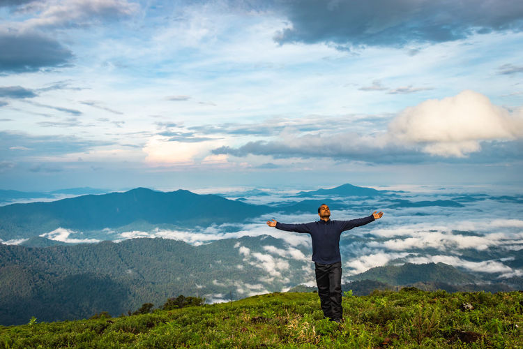 Man in victory pose at mountain top at  morning