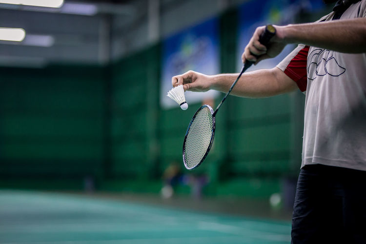 Midsection of man playing badminton