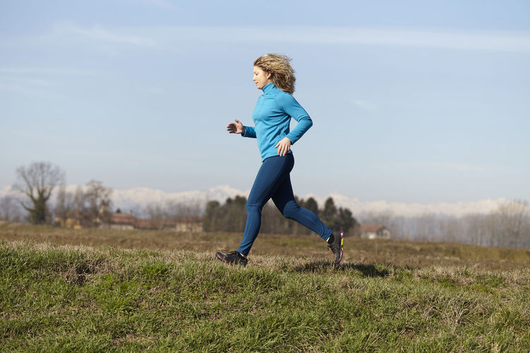 Woman running on grassy field