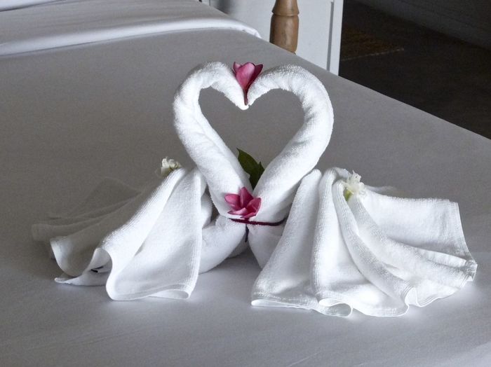 Swan made of white fabric in heart shape on bed