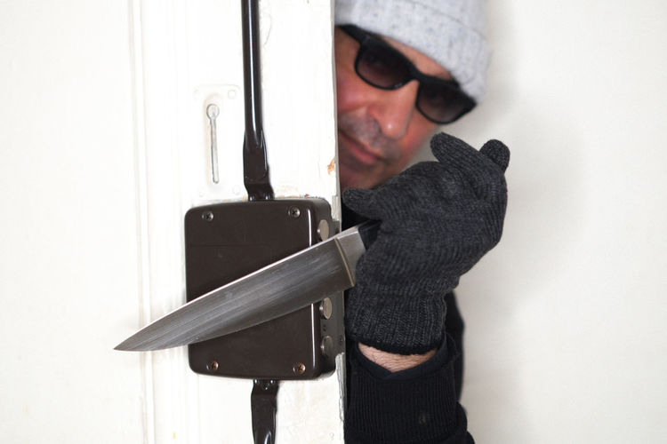 Thief with knife opening door