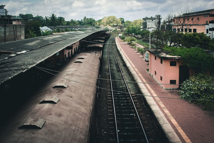 Railroad tracks in city against sky