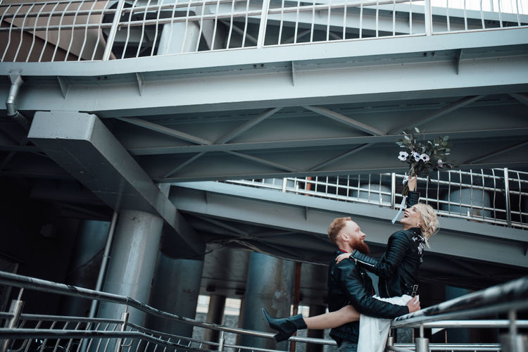 Full length of men standing on railing in city