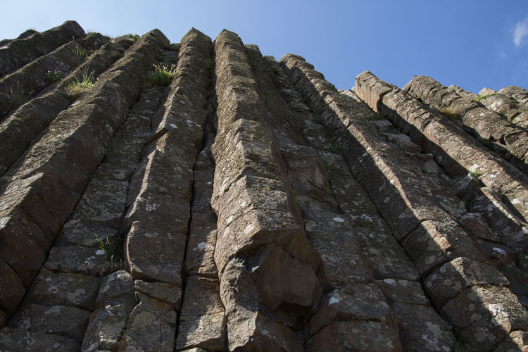 Low angle view of basalt against sky