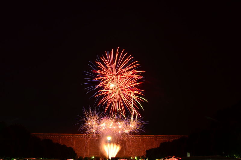 Low angle view of firework display against sky at night