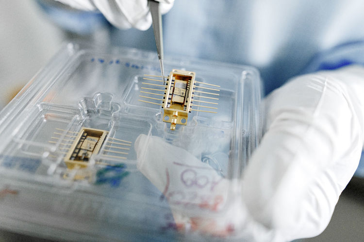 Hands of male scientist unpacking laser chips