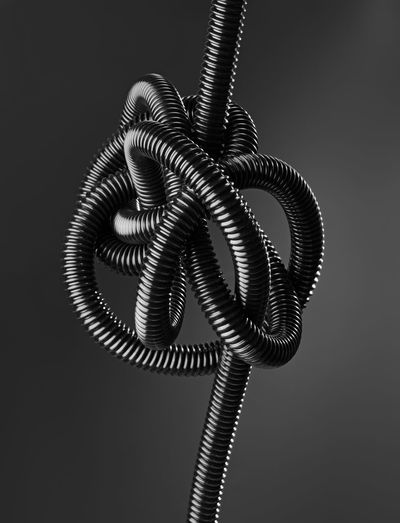 Close-up of tangled phone cord against black background
