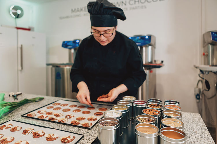 Real female master chef chocolatier working in artisanal professional chocolate laboratory