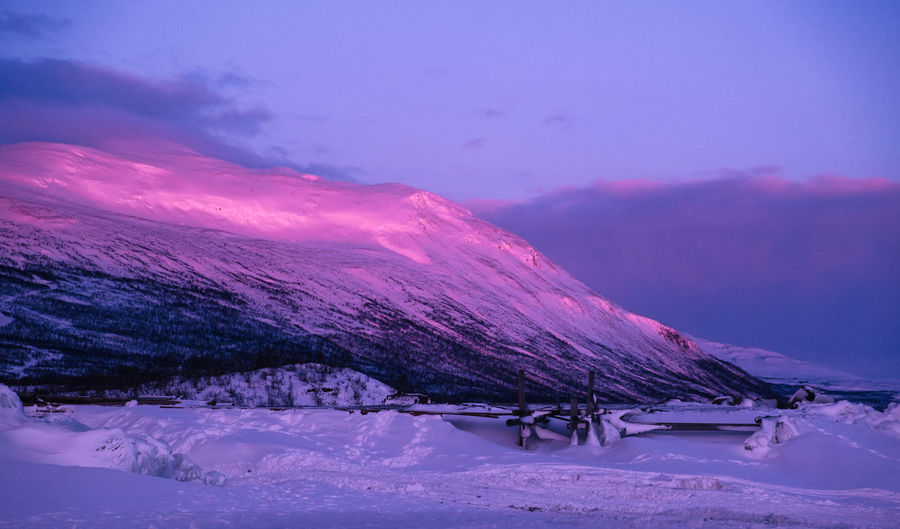 Morning sunrays on a snowcapped montain in abisko, lapland.
