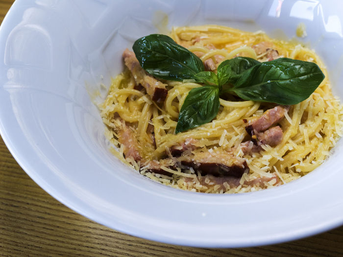 High angle view of pasta with carbonara sauce in bowl on table