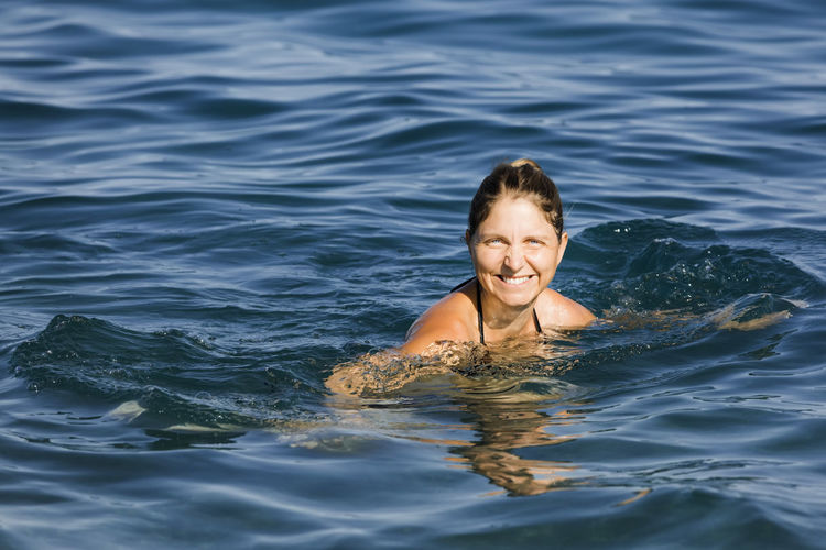 Portrait of smiling boy swimming in sea