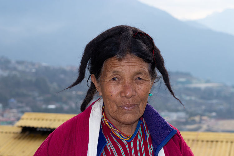 Portrait of woman standing against mountain