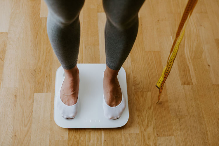 Low section of person standing on weighing scale